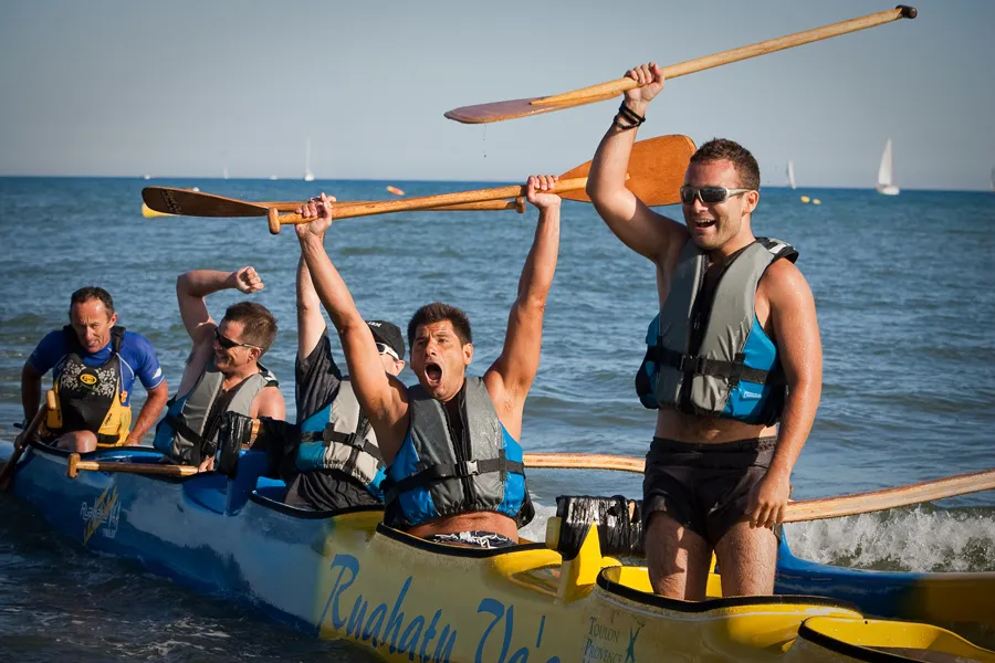 Équipe en pirogue, pagaies levées